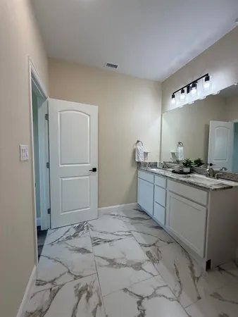 a spacious bathroom with a mirror sink and toilet