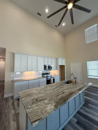 a large kitchen with kitchen island a sink stainless steel appliances and cabinets