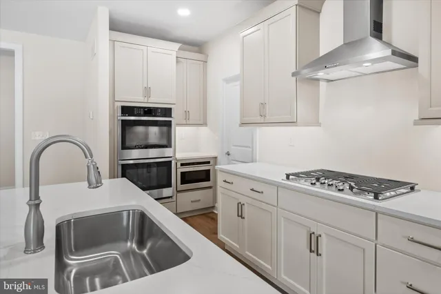 a kitchen with kitchen island a counter space a sink stainless steel appliances and cabinets