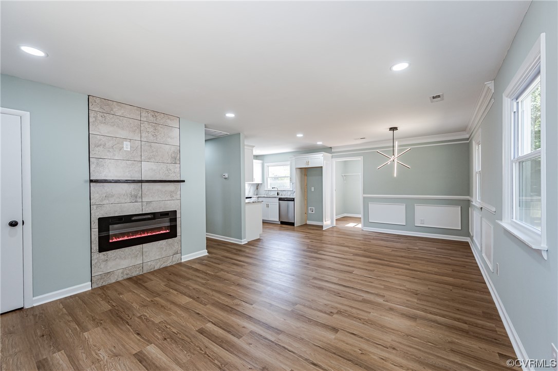 2310 Apollo Road Richmond, VA 23223 - Photo 8 of 22 an empty room with wooden floor fire place and kitchen view