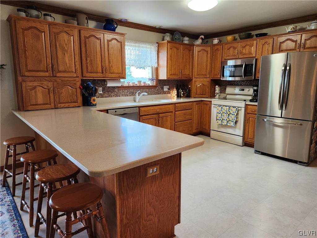 6273 Hower Road Pen Argyl, PA 18072 - Photo 7 of 37 a kitchen with stainless steel appliances granite countertop a refrigerator a sink dishwasher a stove top oven a kitchen island and chairs with wooden floor