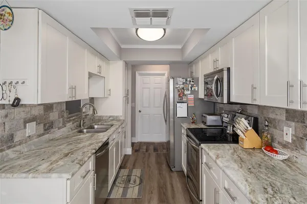 a kitchen with stainless steel appliances granite countertop a sink stove and refrigerator