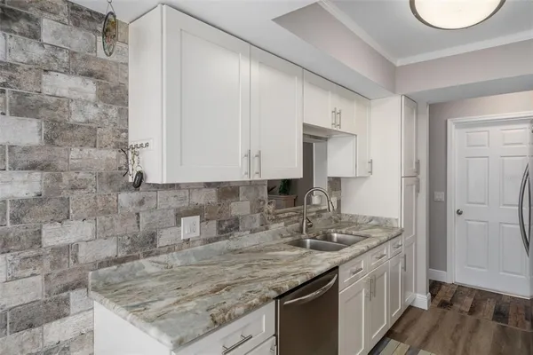 a kitchen with a granite countertop sink and cabinets