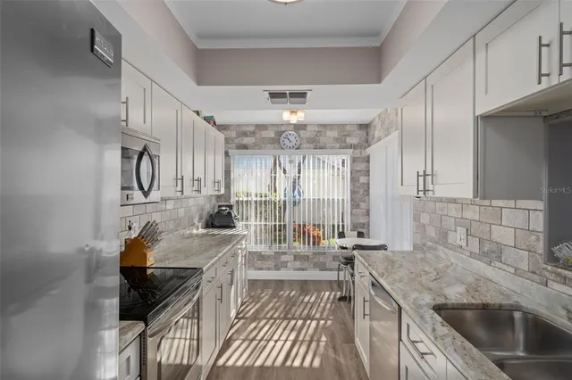 a kitchen with stainless steel appliances granite countertop a sink and cabinets