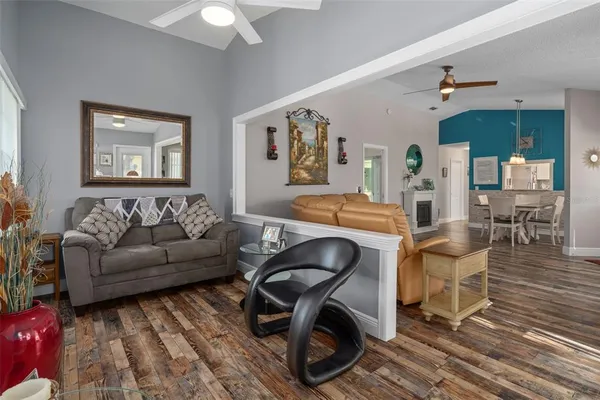 a living room with furniture a wooden floor and next to a window