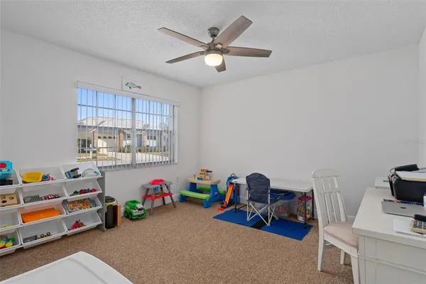 a bedroom with furniture and a fan