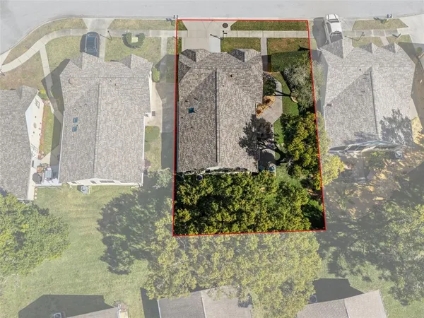 an aerial view of residential houses with outdoor space and parking