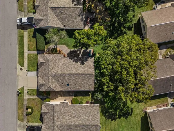 an aerial view of a house with a yard and trees