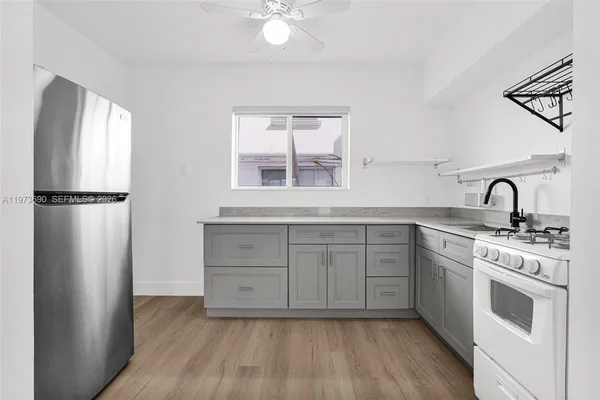 a kitchen with a refrigerator sink and cabinets