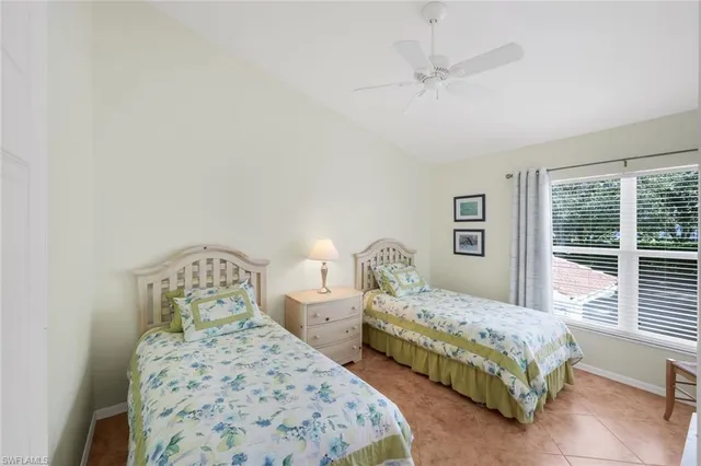 a bedroom with two beds and a large window