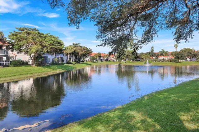 a view of a house with a yard and lake view