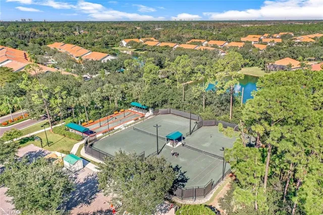 a view of a tennis ground with large trees