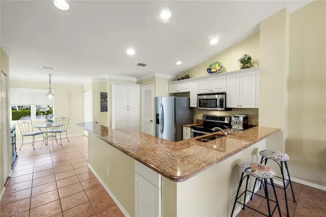 a kitchen with stainless steel appliances granite countertop a sink refrigerator and cabinets