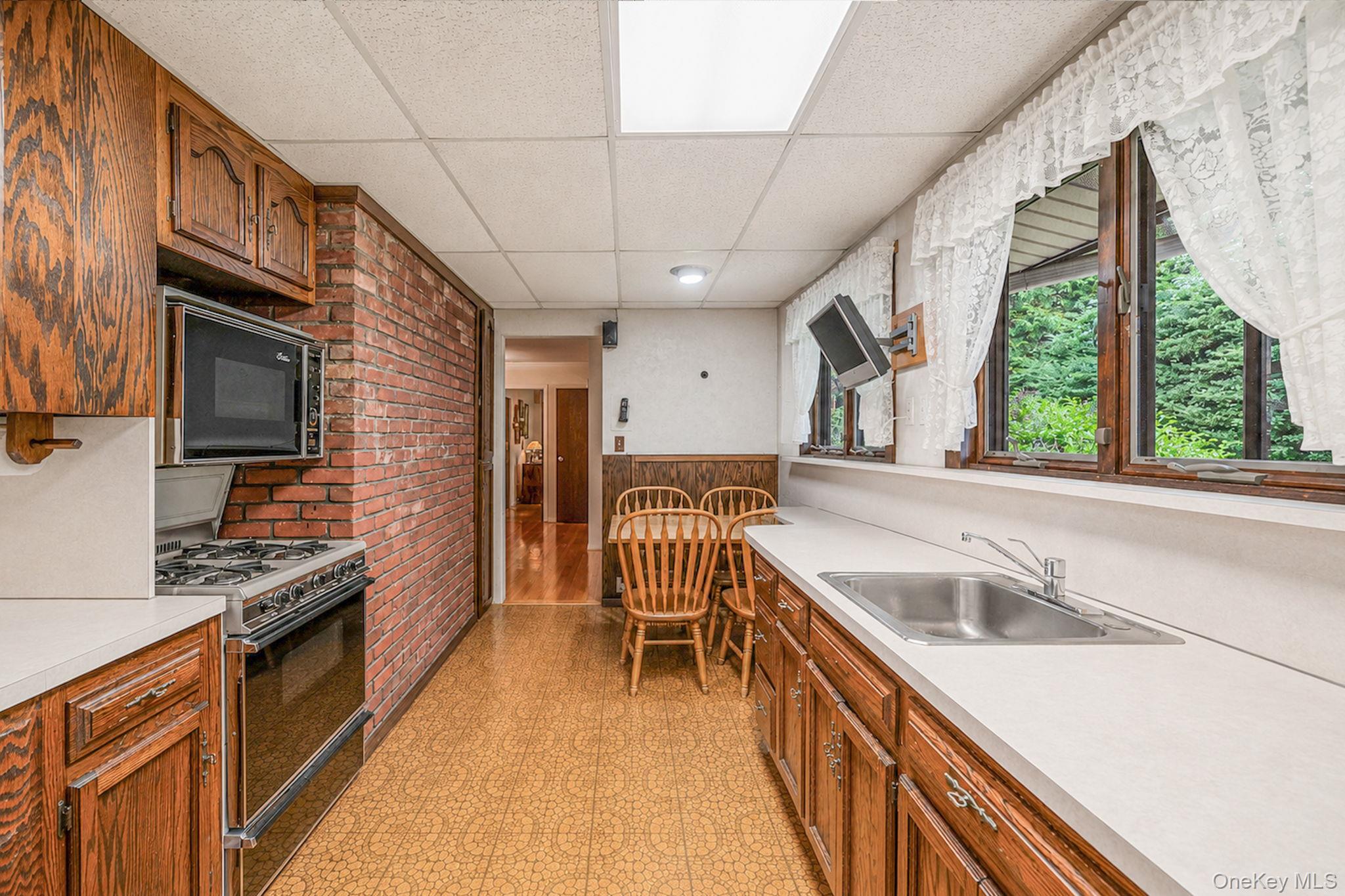 280 Deforest Road North Dix Hills, NY 11746 - Photo 32 of 37 a kitchen with granite countertop a stove a sink and a microwave