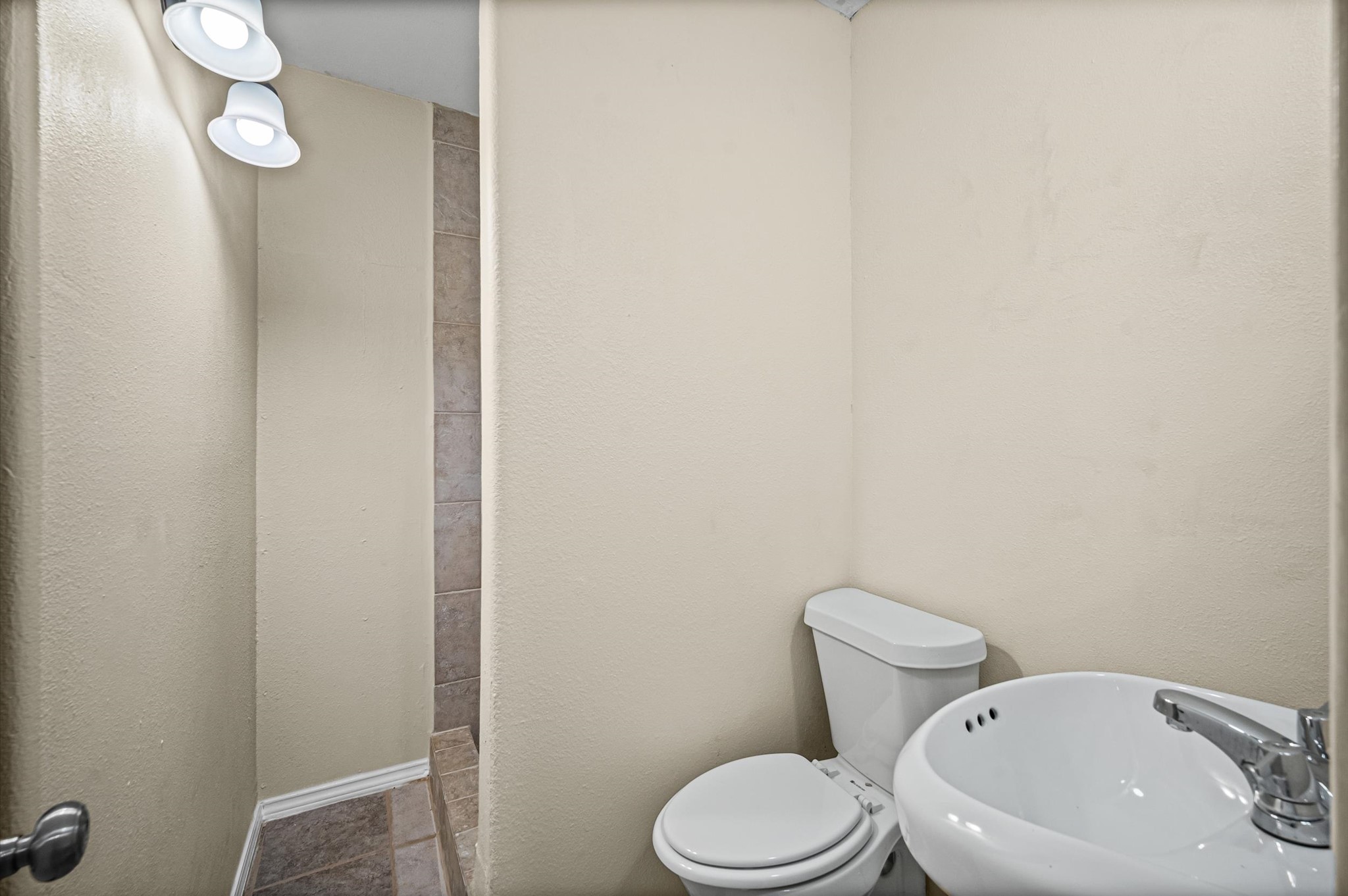 10621 Lane Street Houston, TX 77029 - Photo 10 of 29 a white toilet sitting next to a white sink and vanity