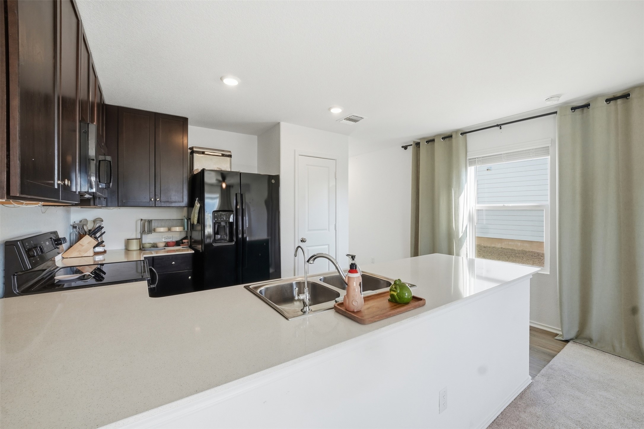 625 Marty Allen Loop Jarrell, TX 76537 - Photo 10 of 25 a kitchen with a refrigerator a stove and a sink with wooden floor