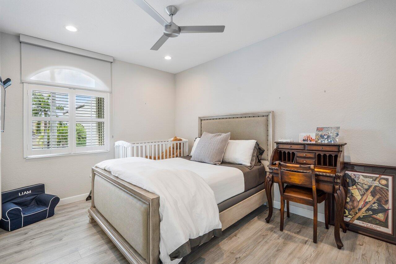 6379 Avalon Pointe Court Boca Raton, FL 33496 - Photo 16 of 37 a bedroom with a bed and a table in it