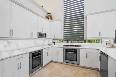 a kitchen with a stove sink and cabinets