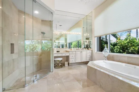 a bathroom with a tub mirror and window