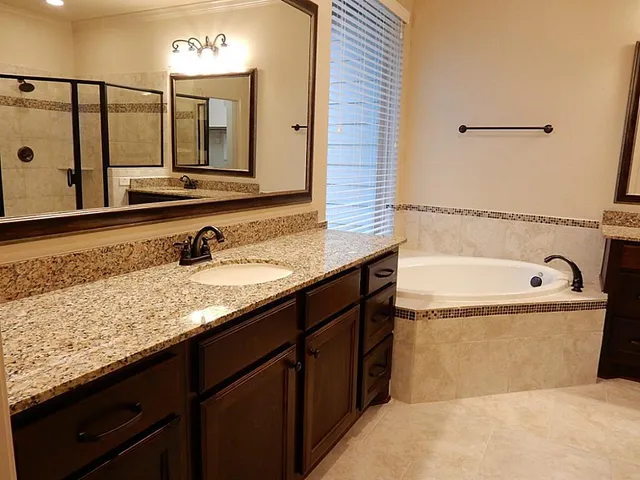 a bathroom with a tub sink and mirror