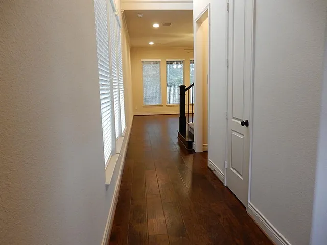 a view of a hallway with wooden floor and closet area