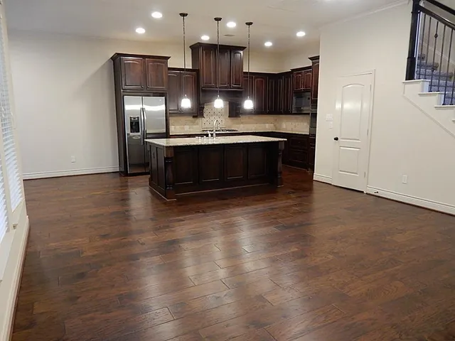 a view of kitchen with refrigerator and wooden floor