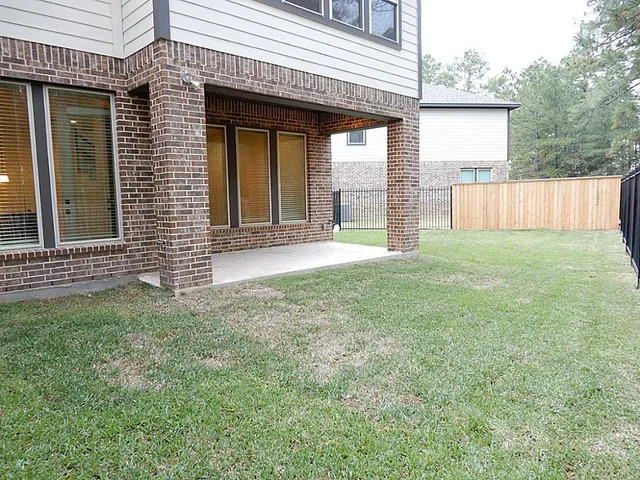 a view of an house with backyard and porch