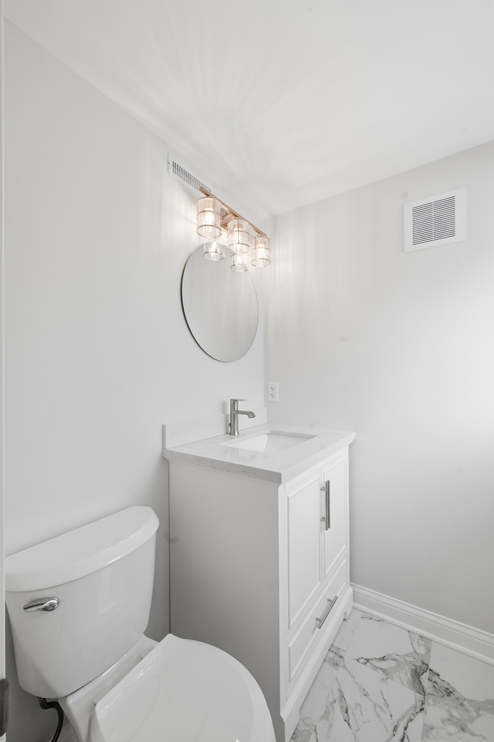 703 West Man A Wa Trail Mount Mount Prospect, IL 60056 - Photo 28 of 35 a bathroom with a toilet a sink and mirror