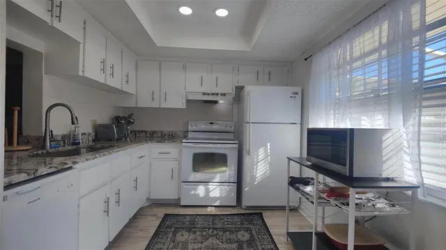 a kitchen with appliances a sink and cabinets