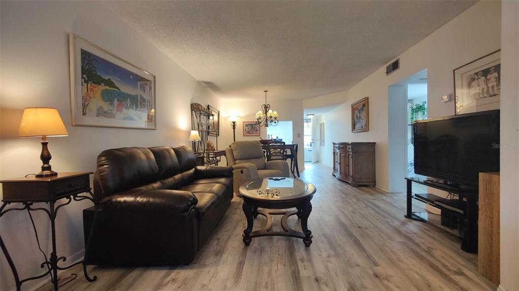 952 Virginia Street, Unit 103 Dunedin, FL 34698 - Photo 9 of 16 a living room with furniture and a flat screen tv