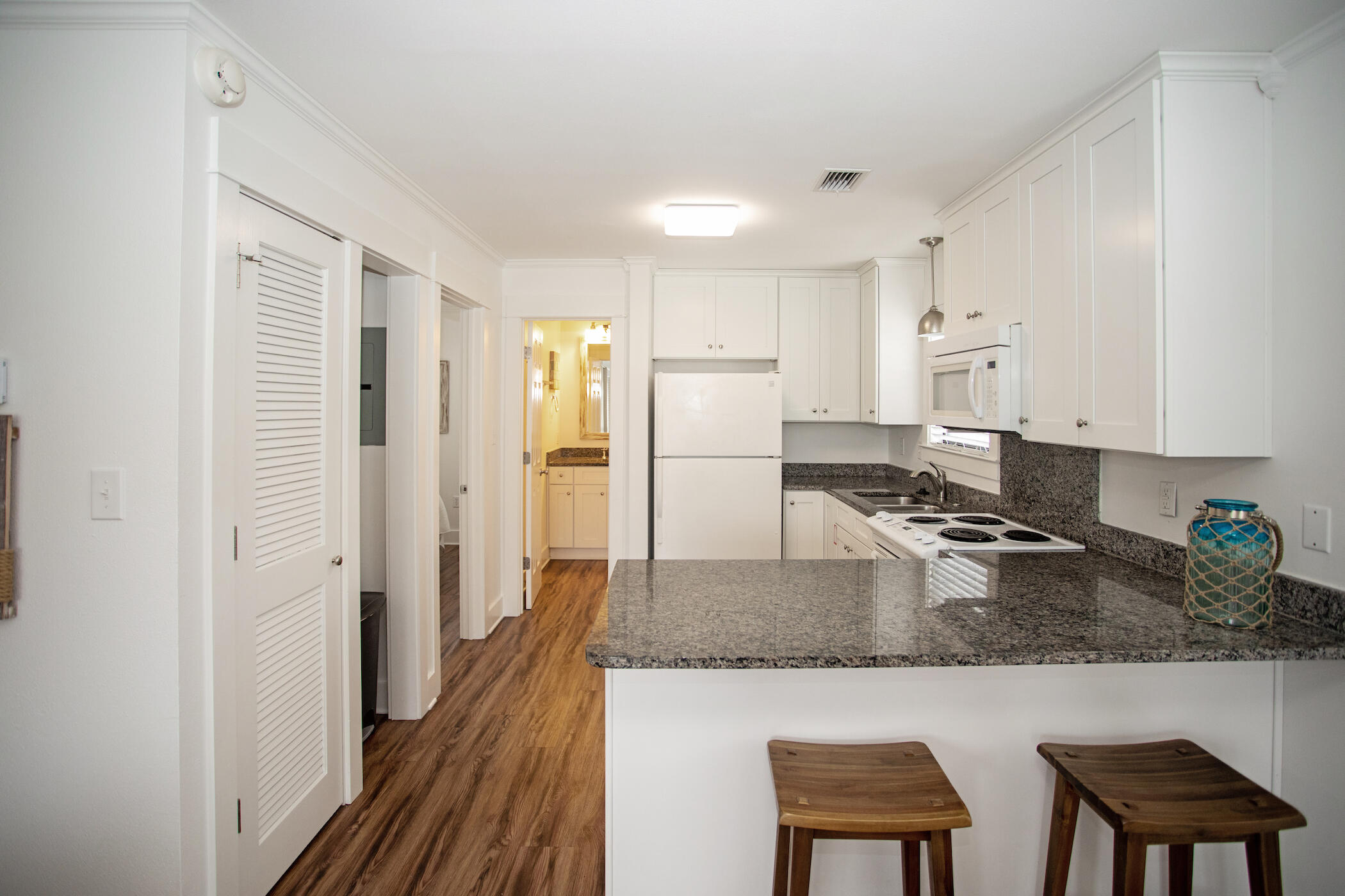 3799 East County Highway 30A, Unit H 2 Santa Rosa Beach, FL 32459 - Photo 12 of 41 a kitchen with stainless steel appliances granite countertop a refrigerator a stove and a sink with wooden floor