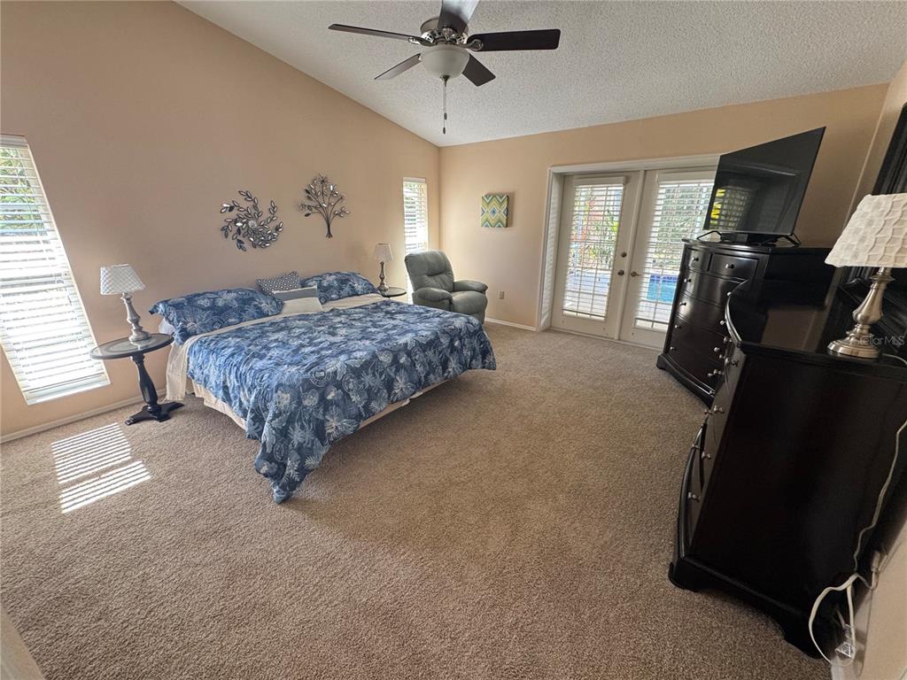 549 Warwick Lane Venice, FL 34293 - Photo 20 of 38 a bedroom with a bed and a chandelier
