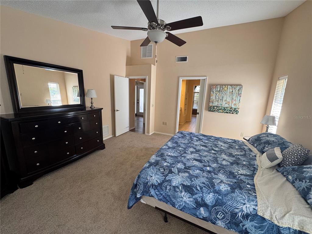 549 Warwick Lane Venice, FL 34293 - Photo 21 of 38 a bedroom with a bed and a flat tv screen on dresser