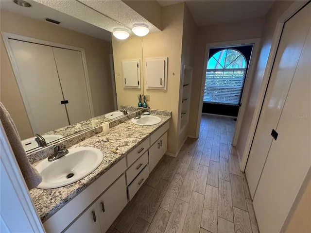 a en suite bathroom with a granite countertop sink and a mirror