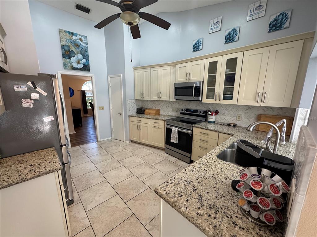 549 Warwick Lane Venice, FL 34293 - Photo 3 of 38 a kitchen with stainless steel appliances granite countertop a sink stove and refrigerator