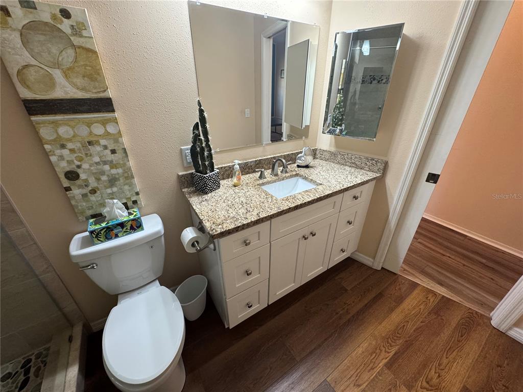 549 Warwick Lane Venice, FL 34293 - Photo 34 of 38 a bathroom with a granite countertop toilet sink and mirror