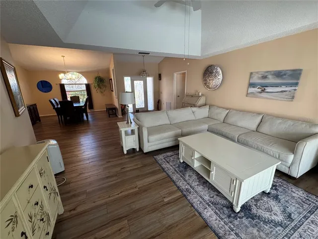 a living room with couches and a large mirror with wooden floor