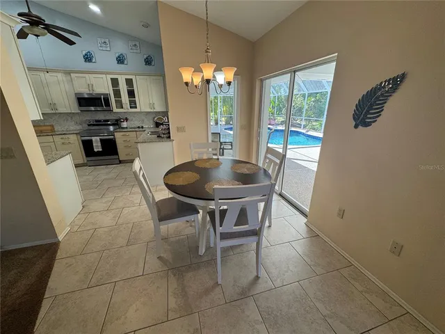 a kitchen with stainless steel appliances a table and chairs in it