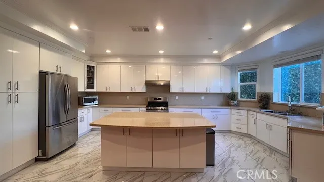 a large kitchen with kitchen island a sink stainless steel appliances and cabinets