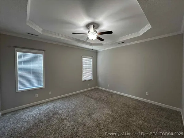en empty room with windows and chandelier fan