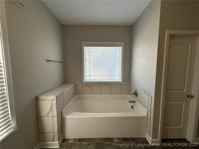 a bathroom with a bathtub and a window