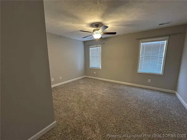 a view of room with a ceiling fan and a window