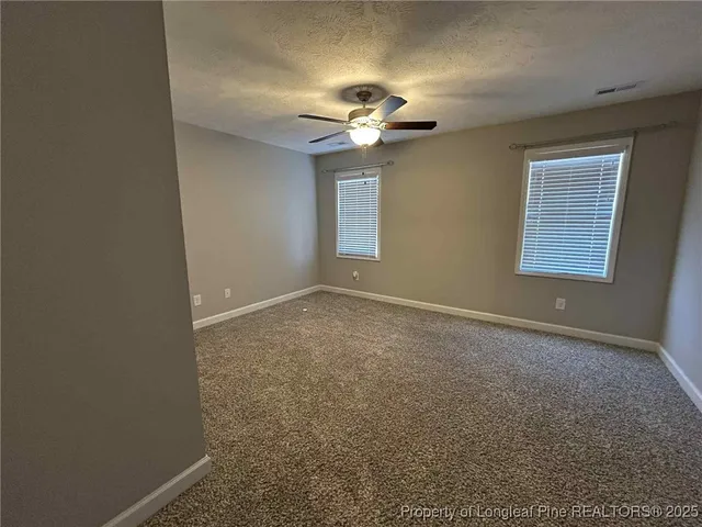 a view of room with a ceiling fan and a window