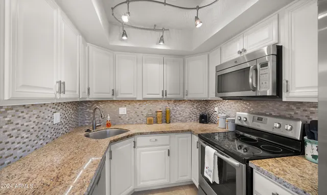a kitchen with stainless steel appliances granite countertop a sink stove and cabinets