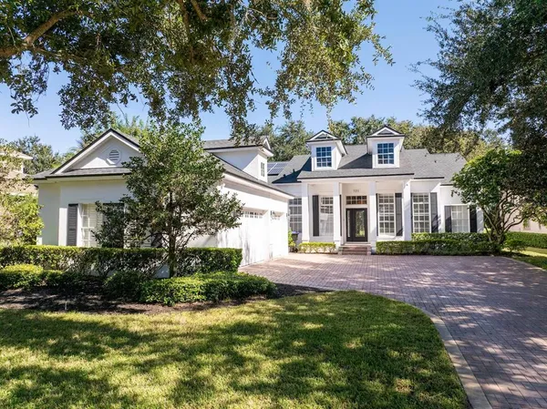 a front view of a house with a yard and trees