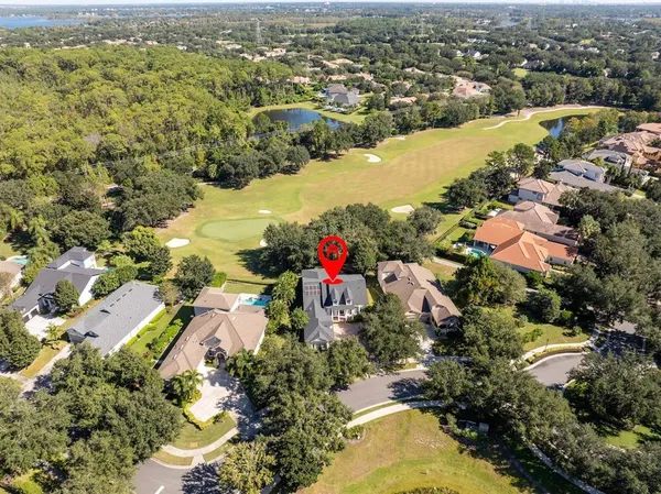a view of an empty room with wooden floor and a ceiling fan