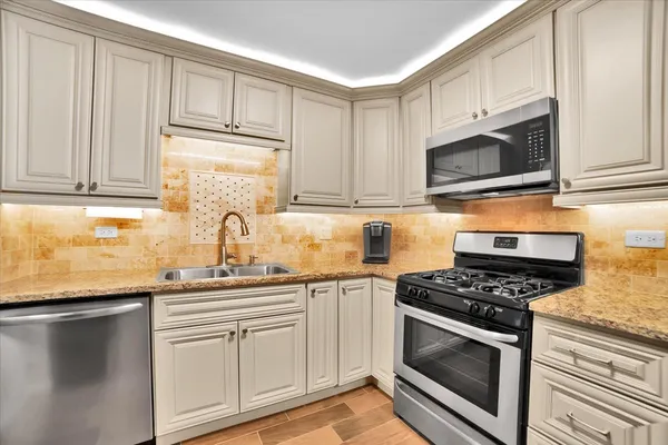 a kitchen with stainless steel appliances granite countertop a sink stove and cabinets