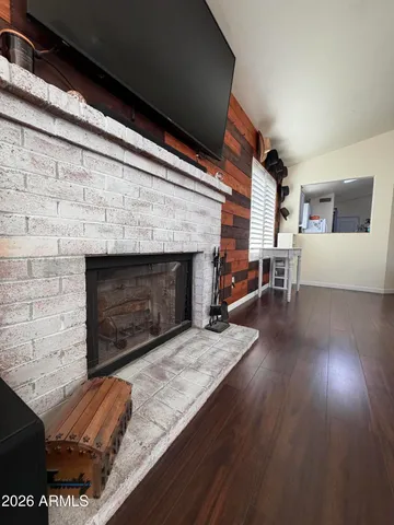an outdoor living room with fireplace and wooden floor