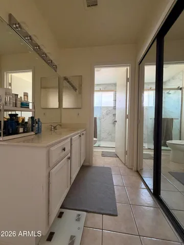 a large white kitchen with a sink and refrigerator