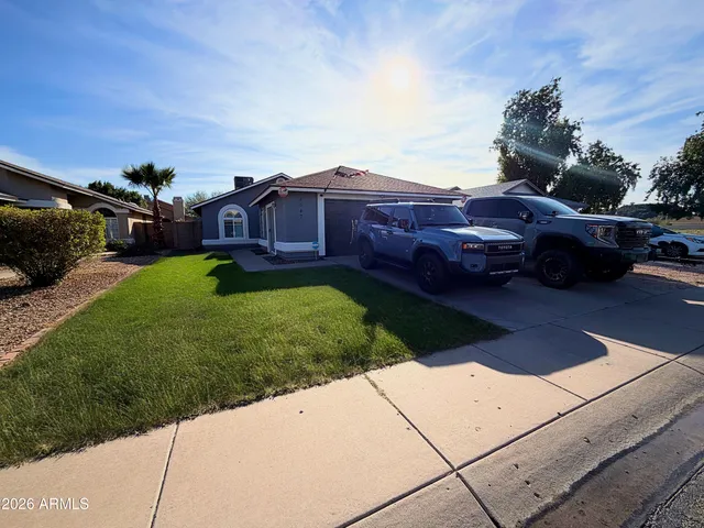 a view of a yard with cars parked in front of it